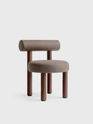 Krzesełko Vintage Designerski, nowoczesny fotel w brązowym kolorze, z zaokrąglonym oparciem i siedziskiem. Stojący na czterech drewnianych nogach, wyróżnia się minimalistycznym stylem i komfortem.