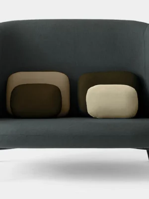 Sofa Urban Luxe Ciemnoszara sofa z trzema poduszkami w odcieniach beżu i oliwkowej zieleni, umieszczonymi na ciemnym tle. Nowoczesny design o prostych liniach, na czarnych, metalowych nogach.